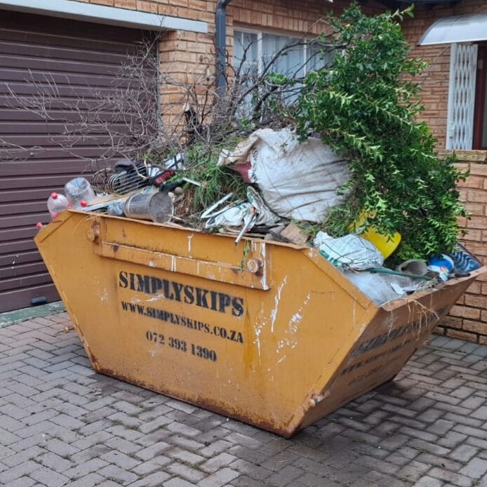 Mini skip bin filled with mixed rubble and garden waste outside a West Rand home